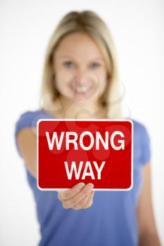 Royalty Free Photo of a Woman Holding a Wrong Way Sign
