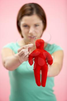 Royalty Free Photo of a Woman Sticking Pins in a Doll