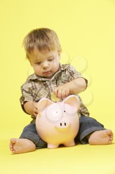 Royalty Free Photo of a Baby With a Piggybank