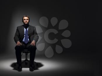 Royalty Free Photo of a Man in a Suit in a Dark Room
