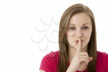 Royalty Free Photo of a Young Girl With Her Finger to Her Lips