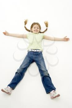 Royalty Free Photo of a Little Girl Lying on the Ground With Her Arms and Legs Spread Out
