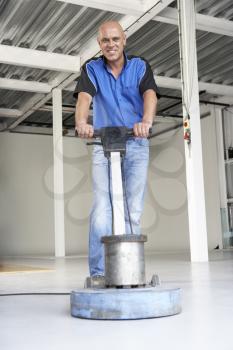 Royalty Free Photo of a Man Cleaning an Office Floor