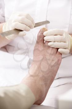 Royalty Free Photo of a Chiropodist Treating a Person