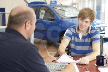 Royalty Free Photo of a Teenager With a Car Salesman