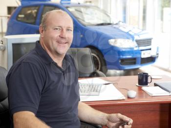 Royalty Free Photo of a Car Salesman in a Showroom