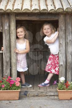 Royalty Free Photo of Two Girls in a Wooden House