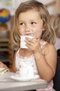 Royalty Free Photo of a Little Girl Having Tea at Day Care