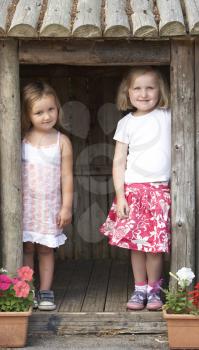 Royalty Free Photo of Girls Playing in a Wooden House