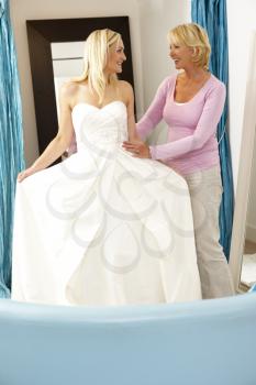 Royalty Free Photo of a Woman Trying on a Bridal Gown With Help