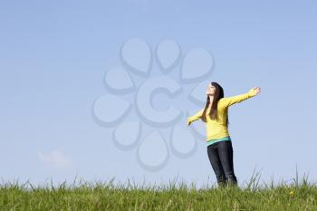 Royalty Free Photo of a Girl in a Field With Her Arms Open