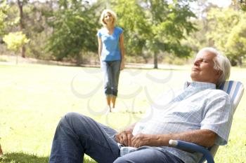 Royalty Free Photo of a Man Sleeping Outside and a Woman Coming Toward Him