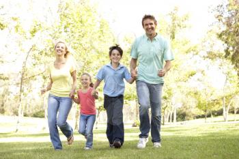 Royalty Free Photo of a Family Running in a Park