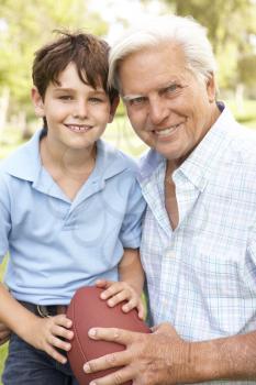 Royalty Free Photo of a Man and His Grandson With a Football