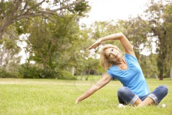 Royalty Free Photo of a Woman Stretching in a Park