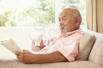 Royalty Free Photo of a Man Reading a Book and Drinking Coffee