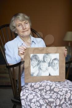 Royalty Free Photo of a Woman With a Picture of Her Grandchildren