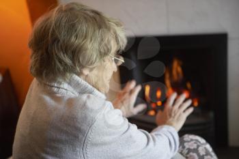 Royalty Free Photo of a Woman Warming Her Hands at a Fire