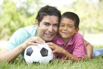 Royalty Free Photo of a Father and Son on the Grass With a Soccer Ball