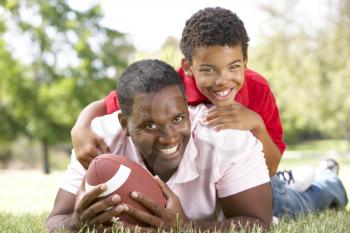 Father And Son In Park With American Football