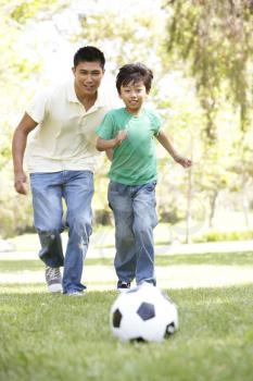 Father And Son In Park With Football