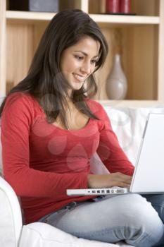 Young Woman Using Laptop Sitting At Home