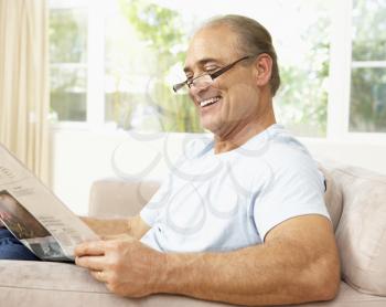 Senior Man Reading Newspaper At Home