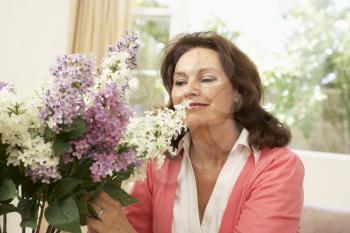 Senior Woman At Home Arranging Flowers