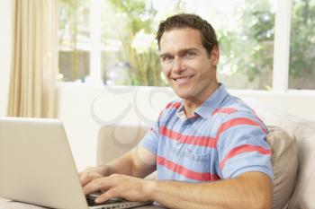 Young Man Using Laptop At Home
