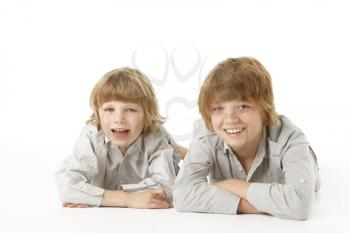 Two Young Boys Lying On Stomach In Studio
