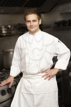 Male Chef Standing Next To Cooker In Restaurant Kitchen