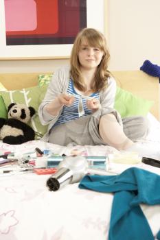 Teenage Girl In Untidy Bedroom Waxing Legs