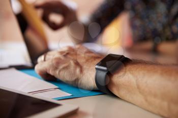 Close Up Of Businessman Wearing Smart Watch In Design Office