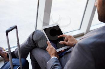 Businessman Using Digital Tablet In Airport Departure Lounge
