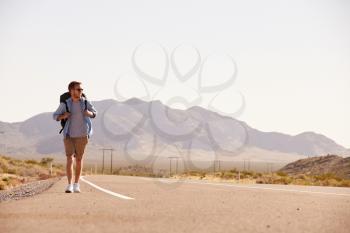 Man On Vacation Hitchhiking Along Country Road