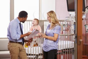 Pediatrician Visiting Mother And Child In Hospital Bed