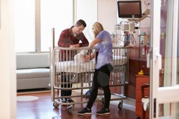 Parents With Daughter In Hospital Pediatric Unit