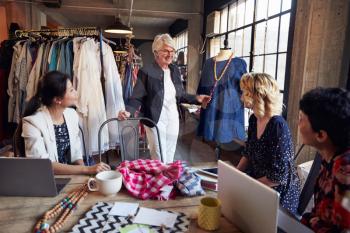 Four Fashion Designers In Meeting Discussing Garment