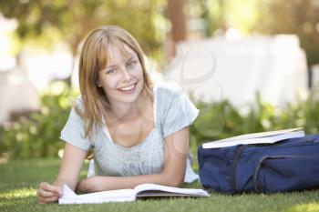 Female Teenage Student Studying In Park
