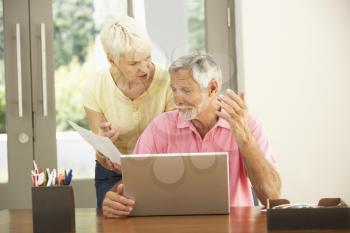 Worried Senior Couple Using Laptop At Home