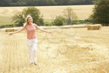 Woman Running Through Summer Harvested Field