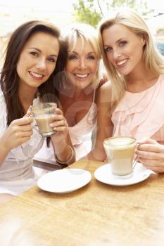 Three Women Enjoying Cup Of Coffee In Caf