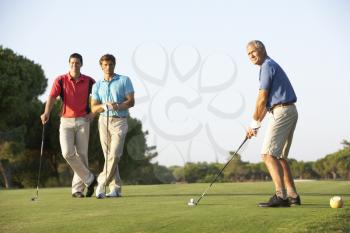 Group Of Male Golfers Teeing Off On Golf Course