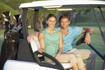 Couple Riding In Golf Buggy On Golf Course