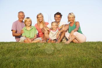 A family, with parents, children and grandparents, posing in a field