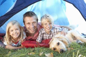 Young father poses with children in tent