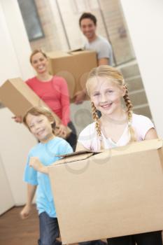 Family happy on moving day carrying cardboard boxes