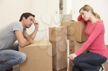 Young couple looking upset among boxes