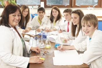 Group Of Teenage Students In Science Class With Tutor