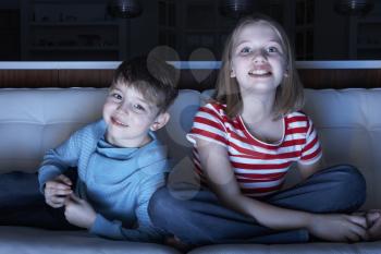 Children Watching TV Together Sitting On Sofa